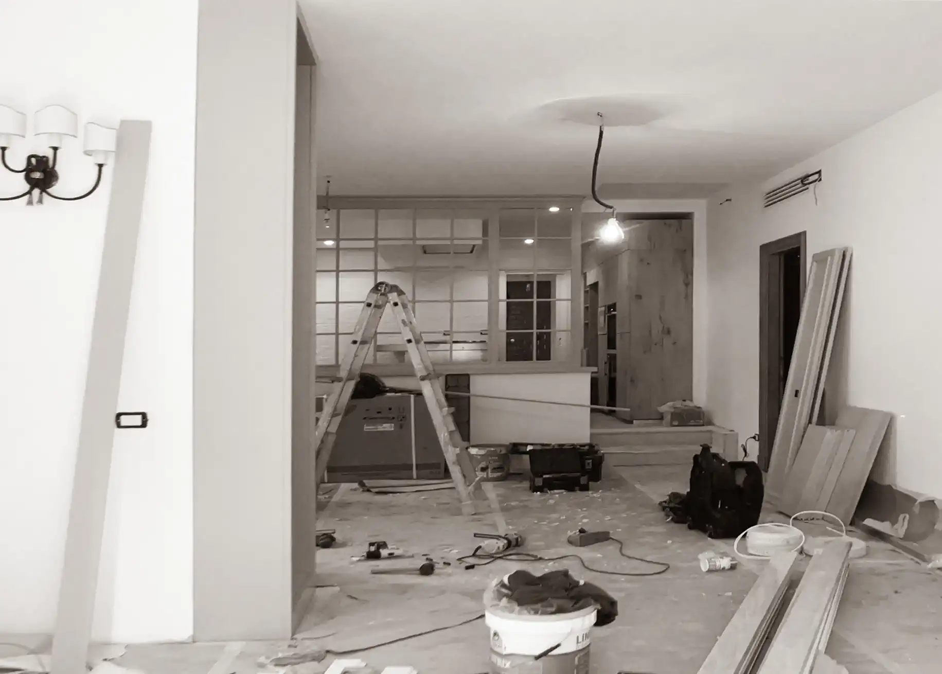 Vista del soggiorno in fase di ristrutturazione a Roma: impianti scoperti e cantiere aperto