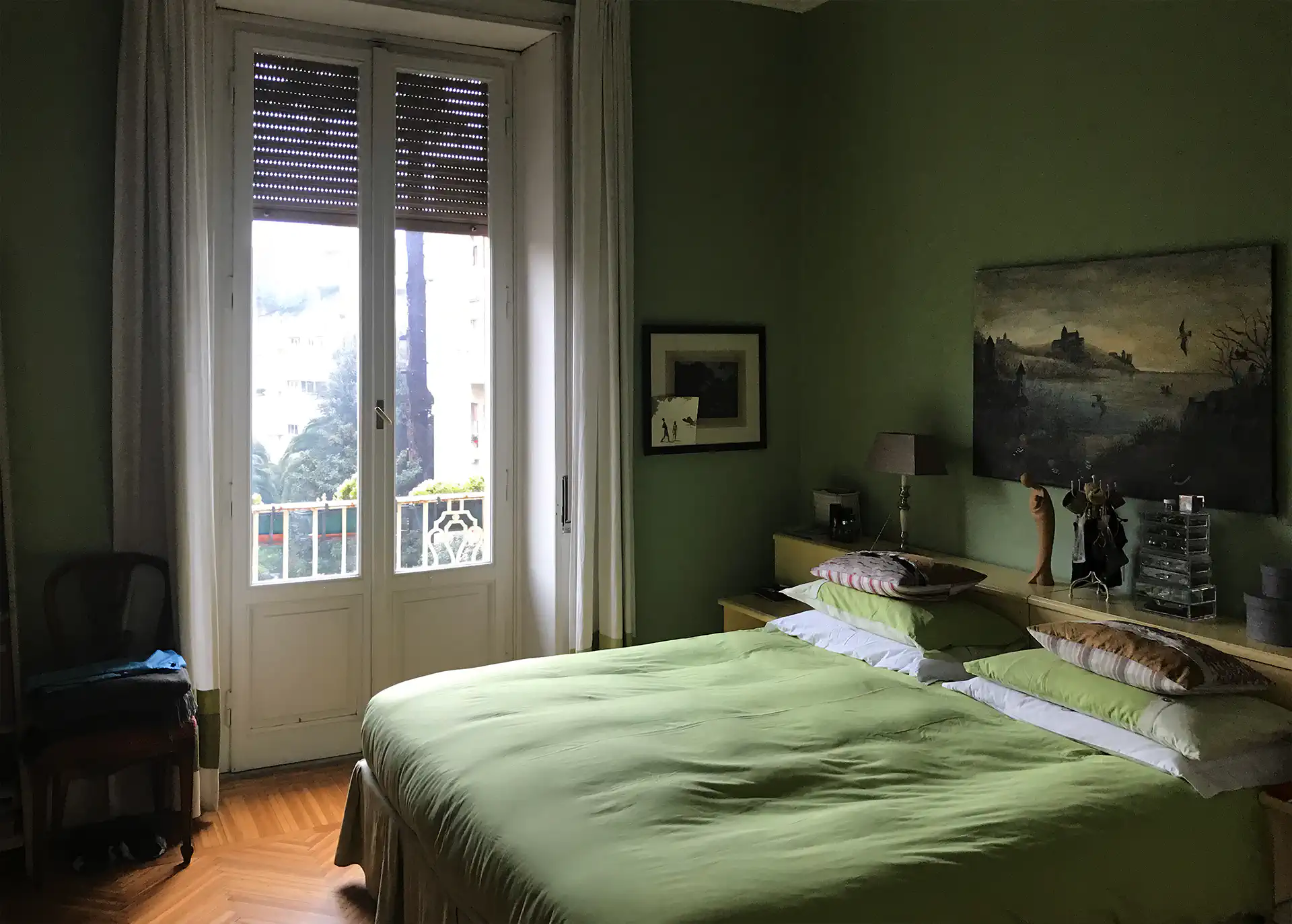 Camera da letto a Roma prima della ristrutturazione: arredi datati e pareti verde oliva