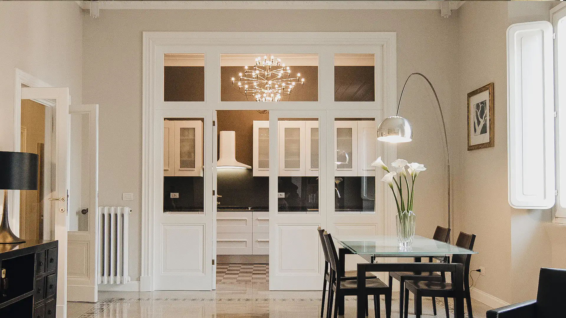 Soggiorno con cucina a vista e vetrata su misura in falegnameria, in appartamento ristrutturato a Roma Trieste