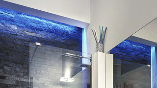 Dettaglio architettonico con pareti in pietra blu e luce radente. Ristrutturazione Prati Roma. (Progetto Colors in love)