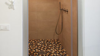 Bagno con doccia e pavimento decorato. Ristrutturazione Casal Palocco Roma. (Progetto riflessi)