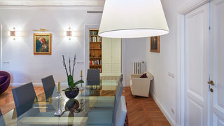 Sala da pranzo con tavolo in vetro, sedie, mobiletti e opere d'arte. Ristrutturazione Parioli Roma. (Progetto Poesie)