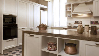 Cucina con mobili bianchi e illuminazione a sospensione. Ristrutturazione Prati Roma. (Progetto Atmosfere)